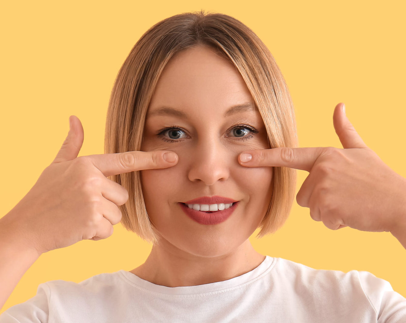 Woman doing face building exercise on yellow background
