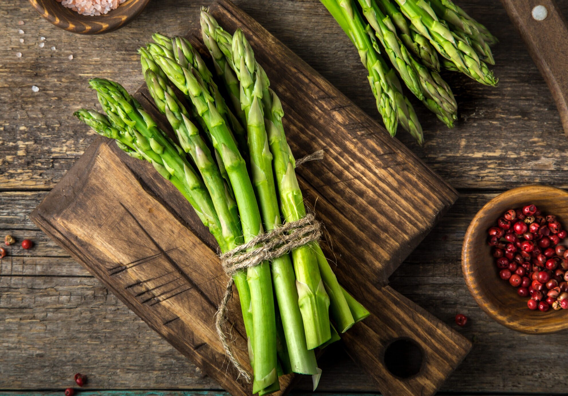 banches of fresh green asparagus on wooden background