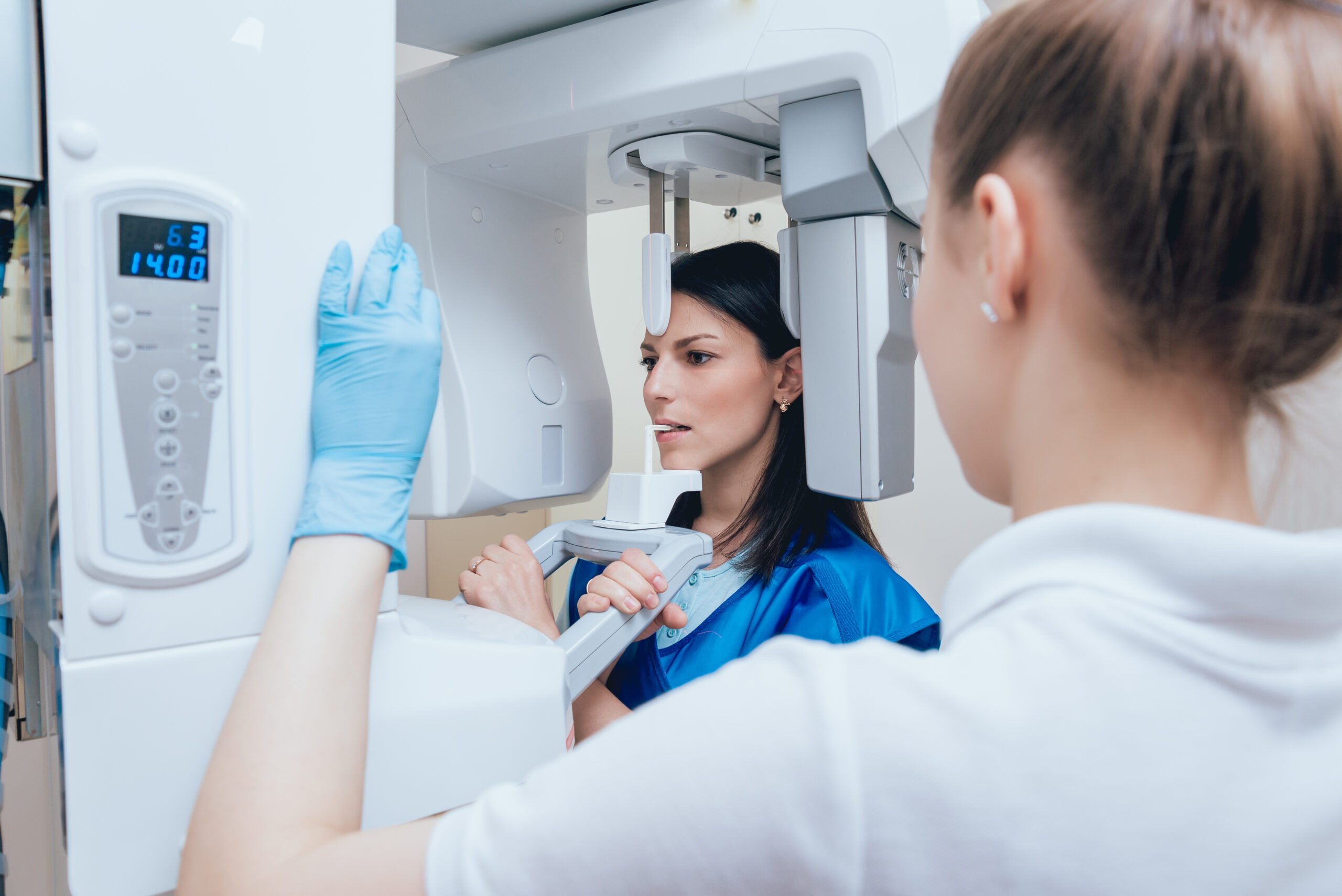 Young woman patient standing in x-ray machine.