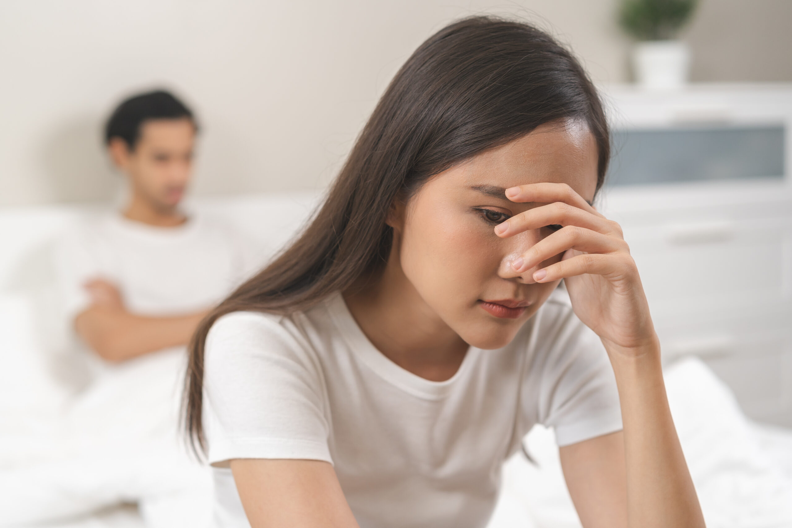 Angry, depressed, frustrated asian couple quarrel, fighting on bed in conflict, divorce or relationship problem, stress from marriage, fight and argument, unhappy married couple and sexual impotent.