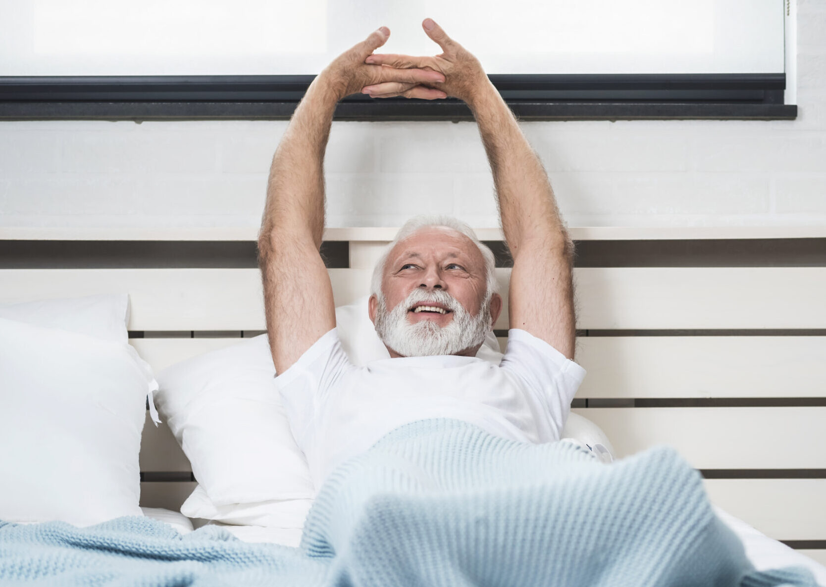 Senior man stretch on bed in morning