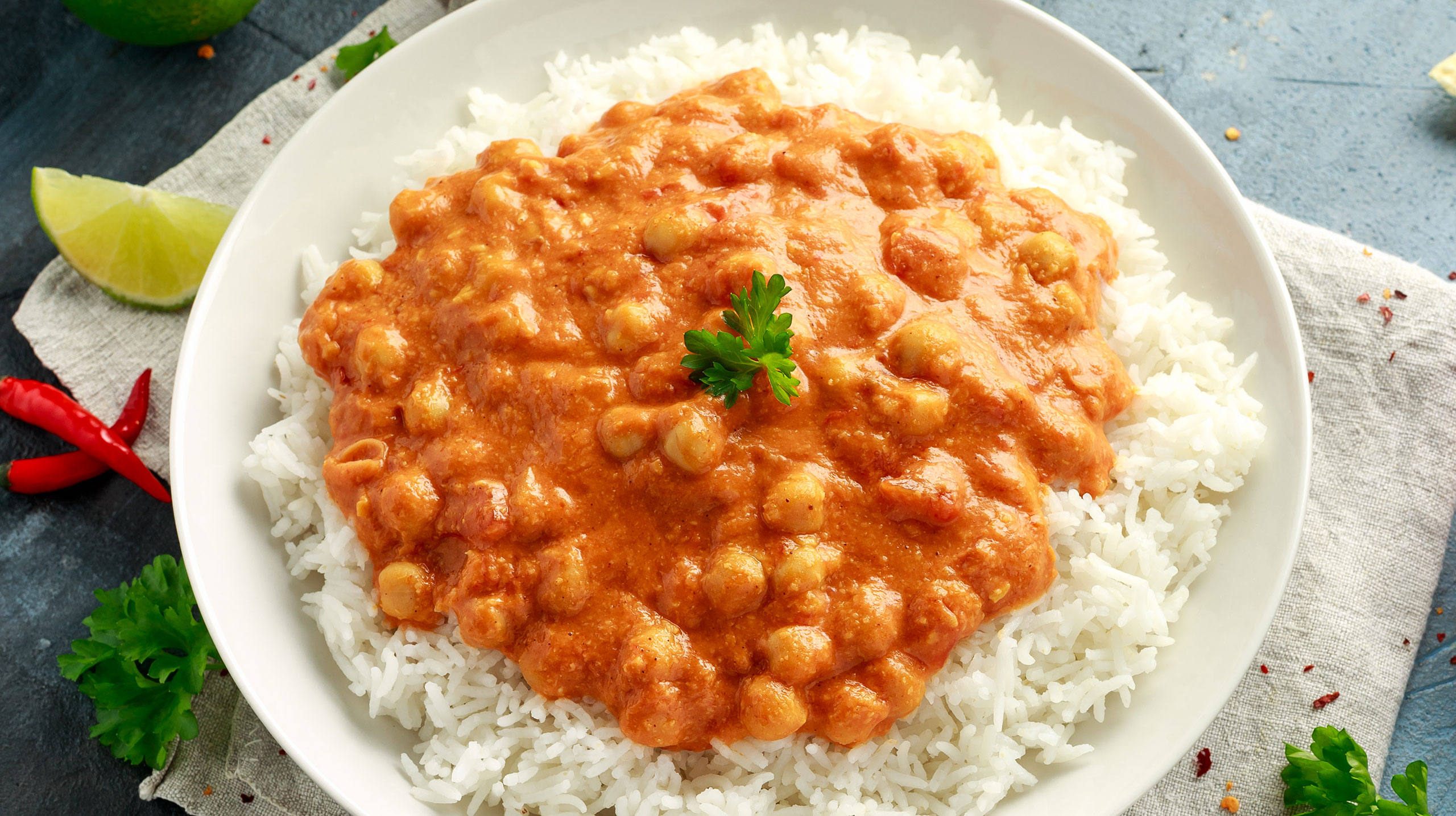 Spicy chickpeas curry with rice, tomato and Poppadoms in white plate. Healthy tasty vegetarian food