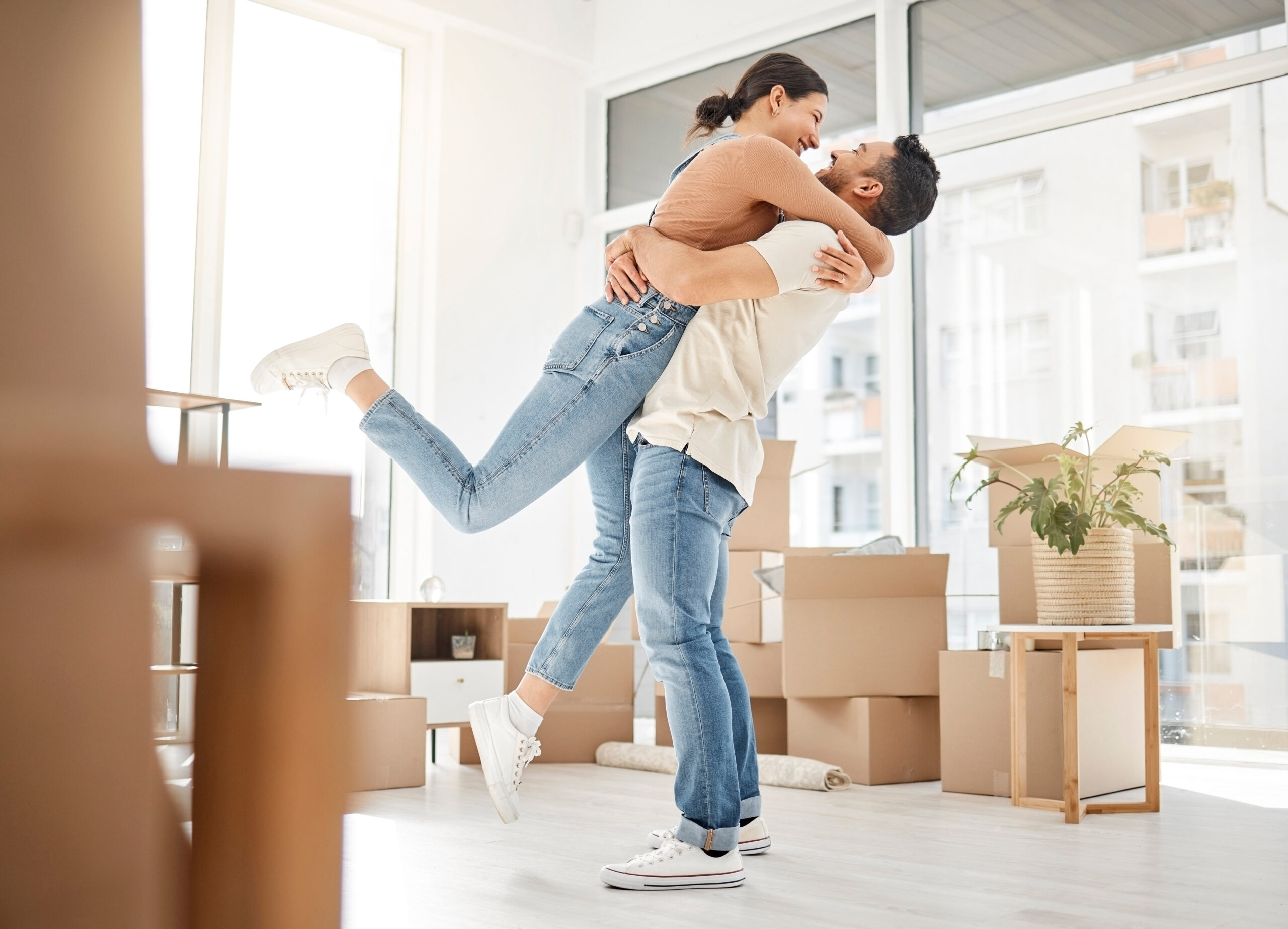 Love, moving and hug with couple in new home for celebration, property and relocation. Excited, happy and real estate with man and woman in living room apartment for investment, rent and homeowner