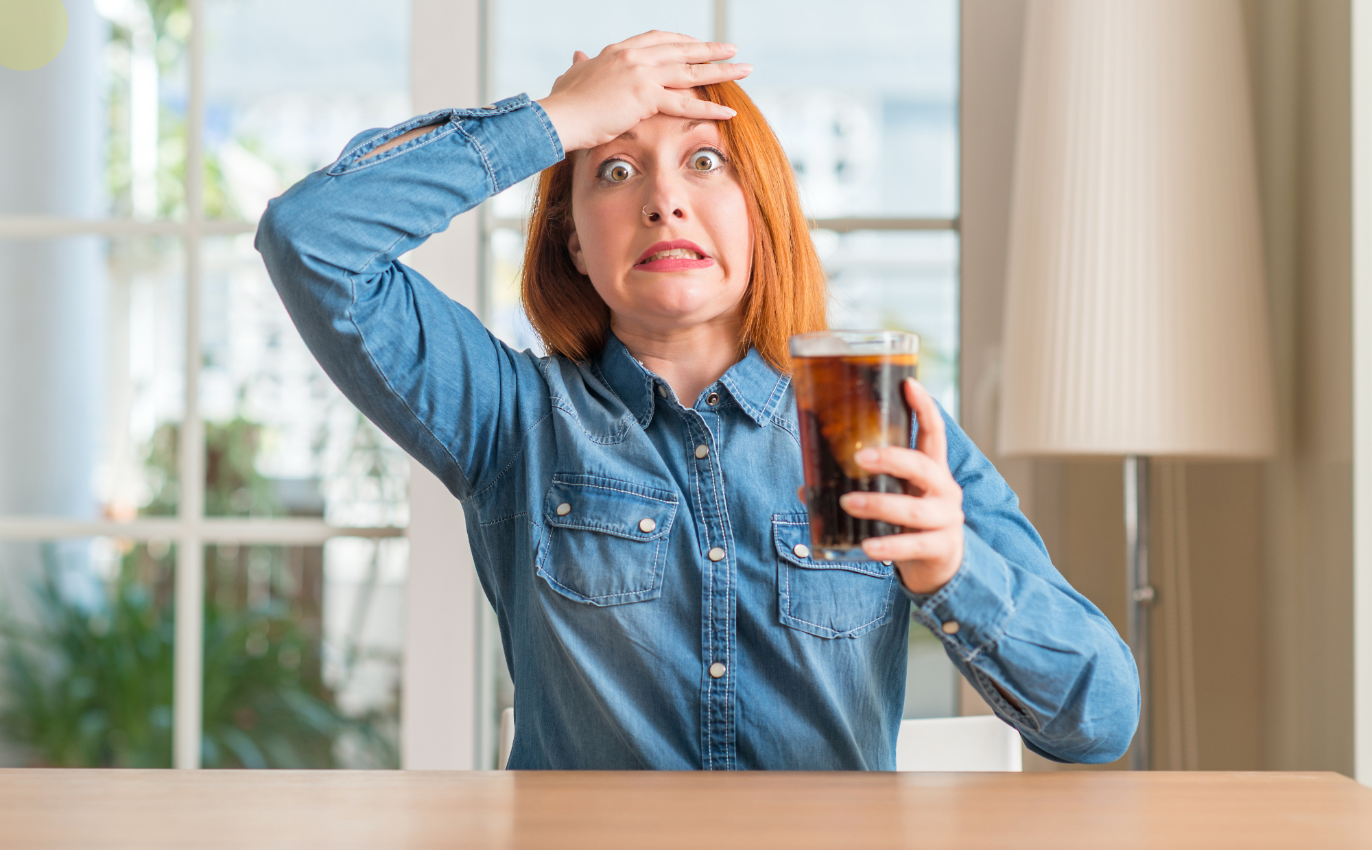 Redhead woman holding soda refreshment stressed with hand on head, shocked with shame and surprise face, angry and frustrated. Fear and upset for mistake.